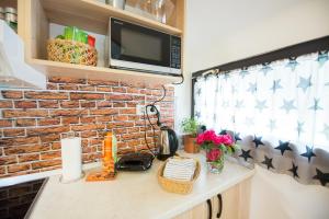 a kitchen counter with a microwave and a brick wall at Boho House 3 in camp Terme Catez in Čatež ob Savi