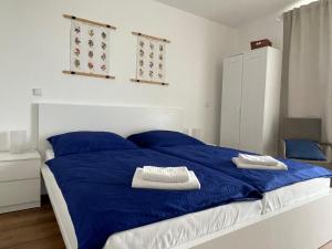 a bedroom with a blue bed with blue pillows at PÁLAVSKÉ DOMKY in Pasohlávky