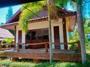 a house on the beach with palm trees at Buddha Raksa in Thong Nai Pan Yai