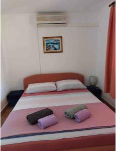 1 dormitorio con 1 cama con 2 almohadas en Sandra Apartmani 3 en Zaostrog
