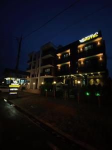 a building with a lit up sign at night at Hotel VS in Kobuleti