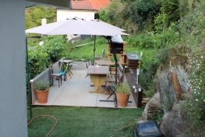 a patio with an umbrella and a table and chairs at Cantinho Casal do Rei in Seia