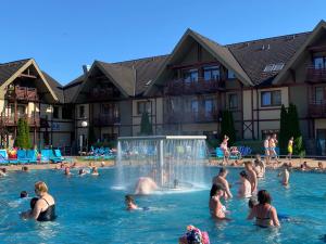 a group of people in the water at a swimming pool at Apartment Family Besenova - free pool in Bešeňová