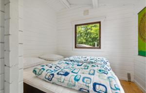 a bed in a white room with a window at Beautiful Home In Rnne With 3 Bedrooms in Rønne