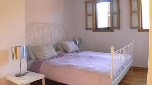 a bedroom with a bed with a purple comforter and two windows at Maison Roxanne & Maisonette in medieval city by Rhodes4vacation in Rhodes Town