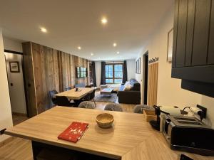 a kitchen and living room with a table and a couch at Arcs 1950 Appartement prestige Ski InOut 6 pax in Bourg-Saint-Maurice
