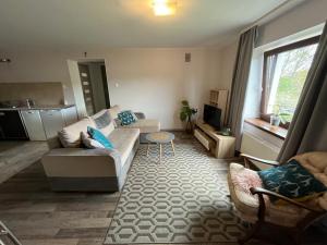 a living room with a couch and a table at Apartament z tarasem in Gdynia