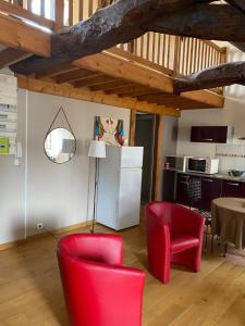 een woonkamer met rode stoelen en een witte koelkast bij Loft duplex de charme 8 p plein centre in Lisieux