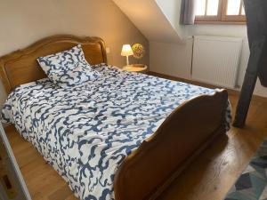 een slaapkamer met een bed met een blauw en wit dekbed bij Loft duplex de charme 8 p plein centre in Lisieux