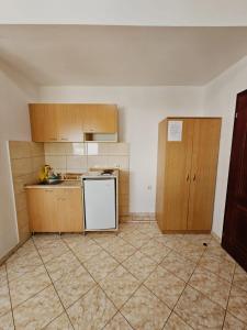 uma cozinha com um frigorífico branco e armários de madeira em Apartmani MIM em Bar