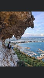 a person sitting on a cliff looking at the water at House boat R al Poetto 2 pax piu' 1 in Poetto