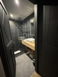 a black bathroom with a sink and a tub at Arcs 1950 Appartement prestige Ski InOut 6 pax in Bourg-Saint-Maurice
