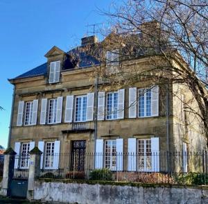 an old stone house with a fence in front of it at Maison de Mags & Mags in Lanouaille