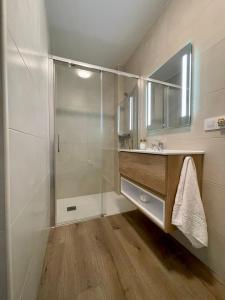 La salle de bains est pourvue d'une douche, d'un lavabo et d'un miroir. dans l'établissement Piso familiar cerca de playa, à Pobra do Caramiñal