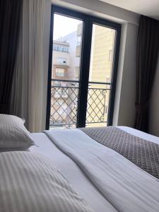 1 dormitorio con cama y ventana grande en Qama Hotel, en Pristina