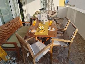una mesa de madera y sillas con comida. en 3 bedrooms Apartman DMT, en Kaštela