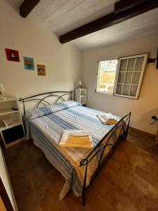 a bedroom with a bed with a blue comforter and a window at Darsena b&b tra arte e mare in Ravenna
