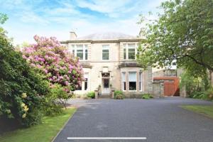 een groot wit huis met een oprit bij Beach lodge with Hot Tub in Ayr