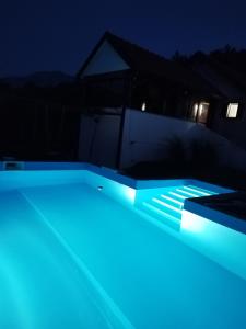 una piscina iluminada por la noche con luces azules en Trebinje - Lastva - Vikendica Vukovic-, en Trebinje