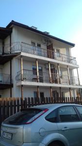 a car parked in front of a building with balconies at Casa Daria in Costinesti