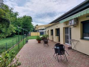 a brick patio with chairs and a building at Szárszó Panzió in Balatonszárszó