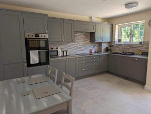 a kitchen with gray cabinets and a table with chairs at The Hideaway in Woodhall Spa