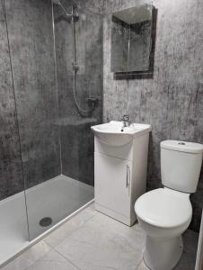 a bathroom with a toilet and a shower and a sink at The Hideaway in Woodhall Spa