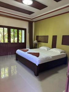 ein Schlafzimmer mit einem großen Bett in einem Zimmer in der Unterkunft Buddha Raksa in Thong Nai Pan Yai