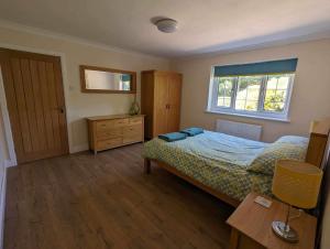 a bedroom with a bed and a dresser and a window at The Hideaway in Woodhall Spa