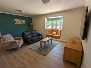 a living room with a leather couch and a table at The Hideaway in Woodhall Spa