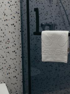 a white towel hanging on a glass shower door at Five Hotel in Astana