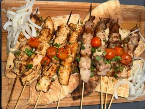 a tray of food with chicken skewers and onions at Elyssia Hotel in Pedoulas