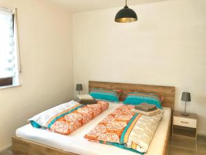 a bedroom with two beds and a pendant light at Ferienapartment Laufen an der Eyach in Albstadt