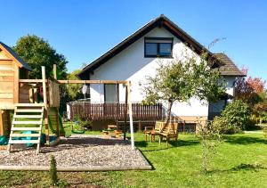 una casa con un parque infantil en el patio en Ferienapartment Laufen an der Eyach, en Albstadt