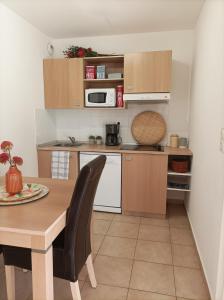 uma cozinha com uma mesa de madeira e um micro-ondas em Appartement T2 bord de mer/piscines em Moriani Plage