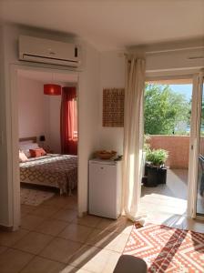 um quarto com uma cama e uma porta de vidro deslizante em Appartement T2 bord de mer/piscines em Moriani Plage