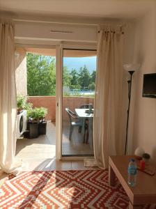 uma sala de estar com uma porta que abre para um pátio em Appartement T2 bord de mer/piscines em Moriani Plage