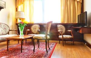 uma sala de estar com uma mesa e cadeiras e uma televisão em Hotel Olympik em Praga
