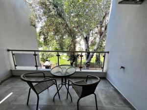 a balcony with a table and chairs and a large window at Nikiti Holidays in Nikiti