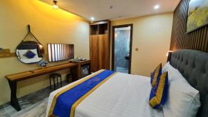 a bedroom with a bed and a desk and a mirror at LA MIA Lakeview Hotel in Pleiku