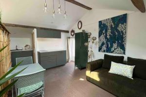 a living room with a couch and a kitchen at Appartement - Galerie BOTANIC ART Trentemoult in Rezé