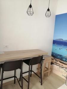 een eetkamer met een houten tafel en 2 stoelen bij Casa dei Mulini in Favignana