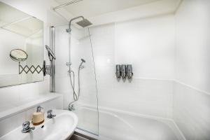a white bathroom with a shower and a sink at Train Station Serenity in Staines upon Thames