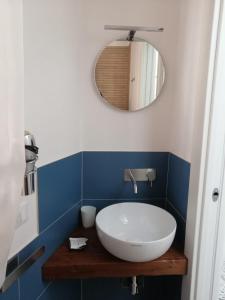 a bathroom with a white sink and a mirror at Casa dei Mulini in Favignana