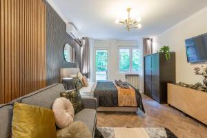 - un salon avec un canapé et un lit dans une chambre dans l'établissement Stylish Quentin Apartment in the King Street, à Budapest