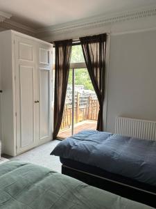 a bedroom with a bed and a door to a balcony at Up up and away stays in Norwood
