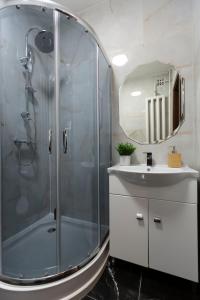 La salle de bains est pourvue d'une douche, d'un lavabo et d'un miroir. dans l'établissement Stylish Quentin Apartment in the King Street, à Budapest