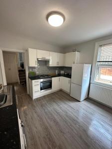 a kitchen with white cabinets and a white refrigerator at Up up and away stays in Norwood