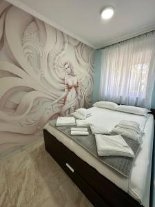 a bedroom with a wall mural of a woman at Spa apartman Sobhe in Vrnjačka Banja