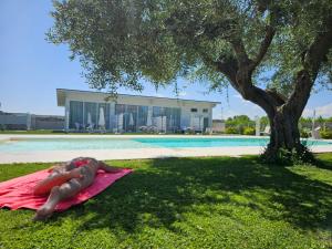 a man laying on a towel next to a swimming pool at Luxury Pool Suites - Città Bianca in Pescara